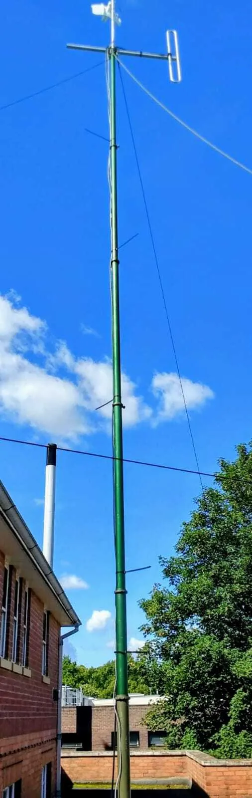 Guyed radio mast above site buildings